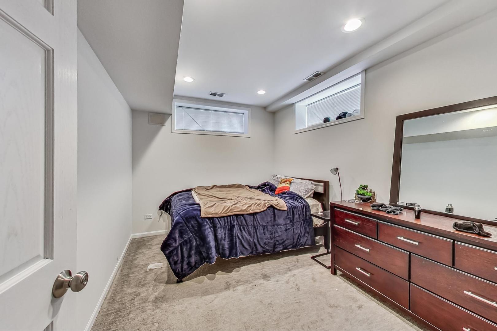 1119 West Addison Street Chicago, IL 60613 - Photo 21 of 36 a room with a bed and a dresser in it