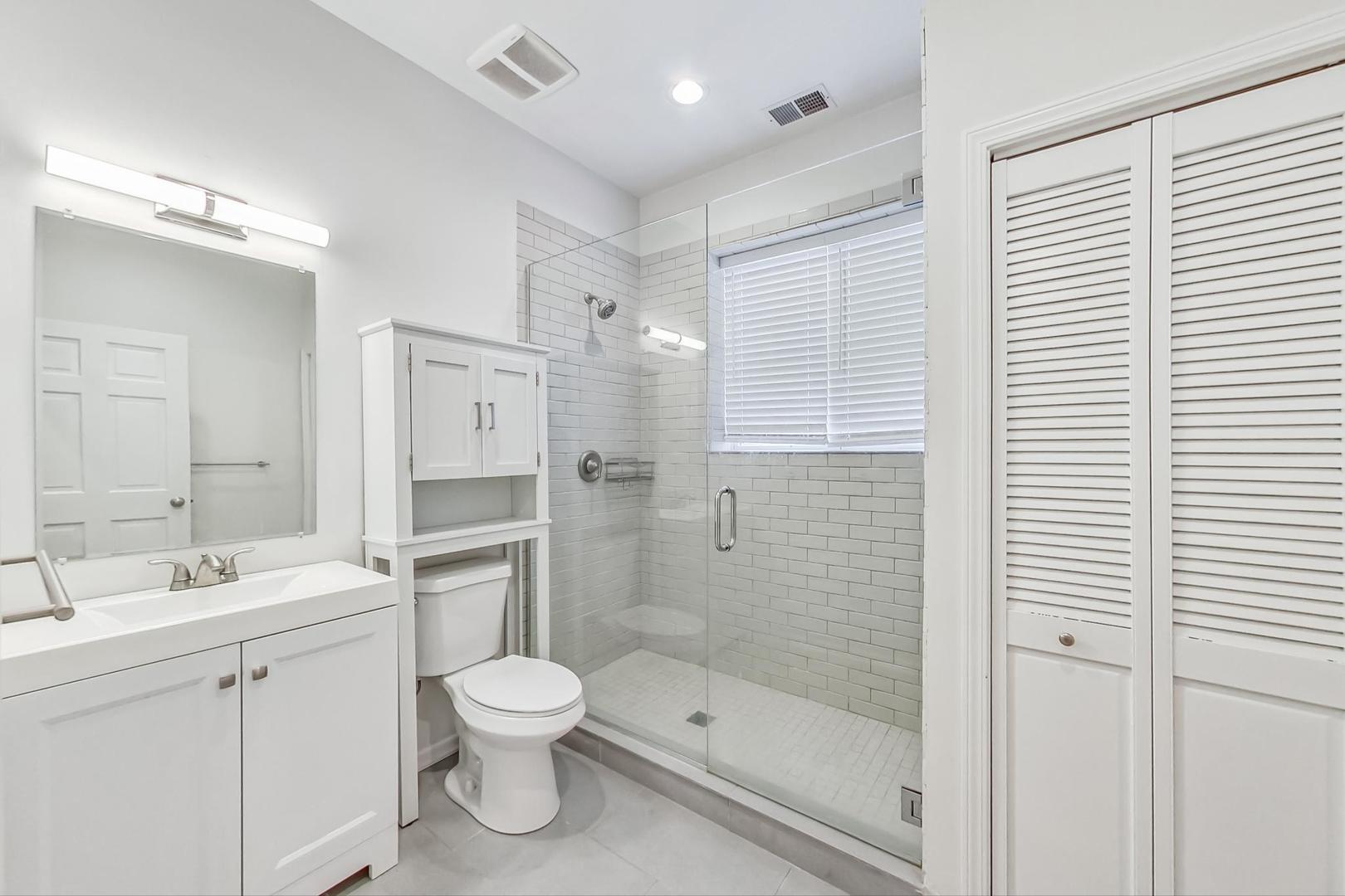 1119 West Addison Street Chicago, IL 60613 - Photo 28 of 36 a bathroom with a toilet a sink and a large mirror