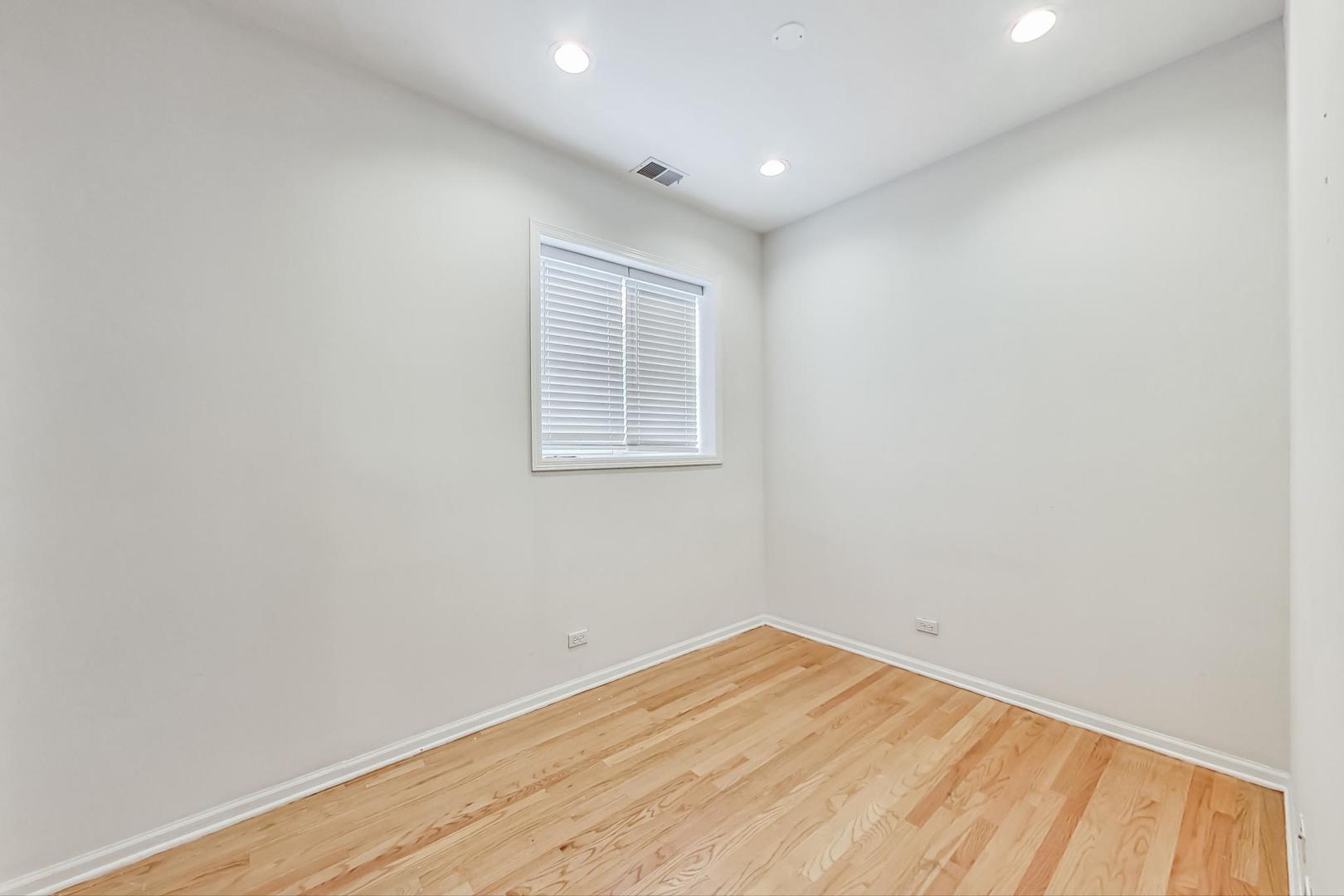 1119 West Addison Street Chicago, IL 60613 - Photo 30 of 36 an empty room with wooden floor and windows