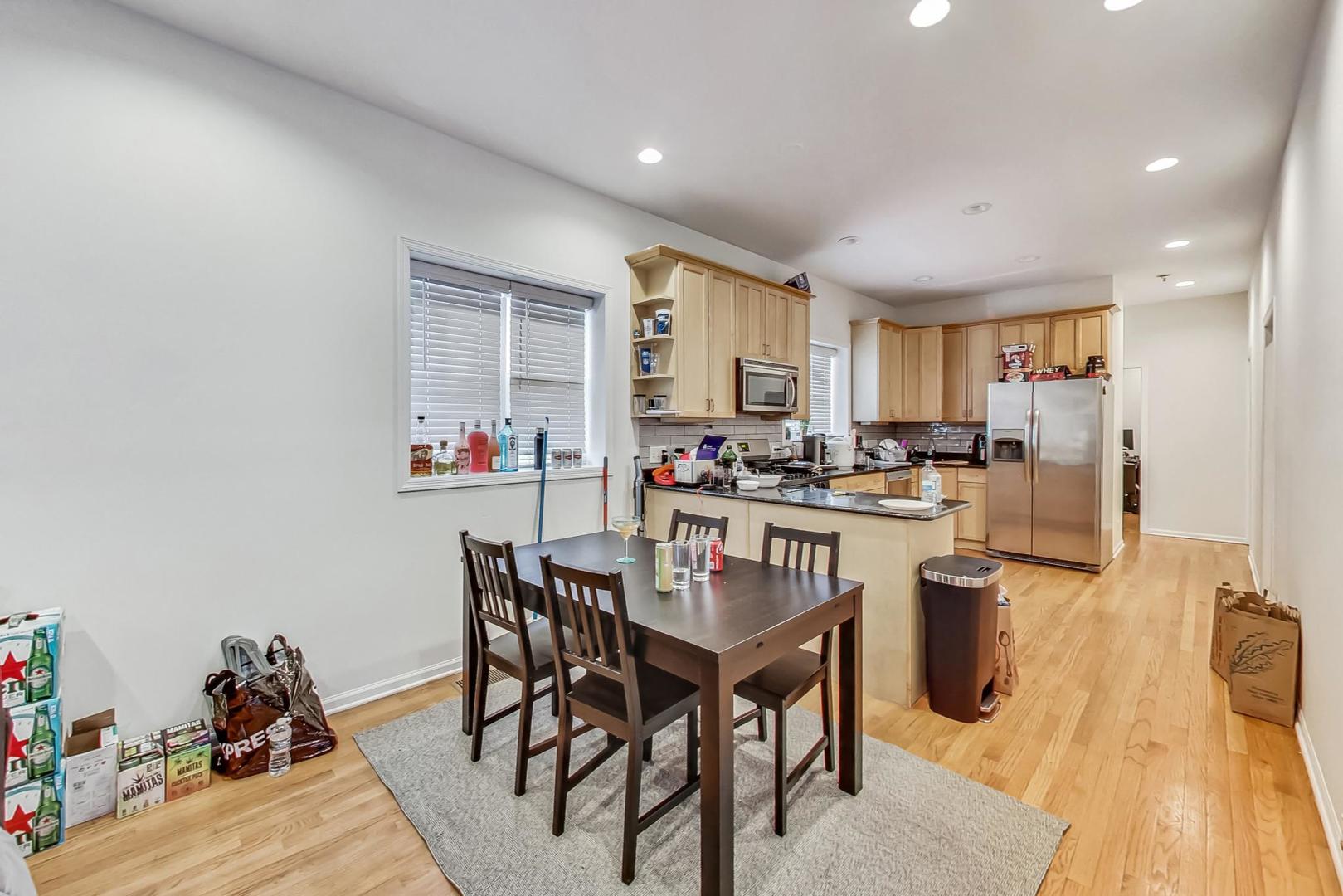 1119 West Addison Street Chicago, IL 60613 - Photo 6 of 36 a kitchen with a dining table chairs and refrigerator