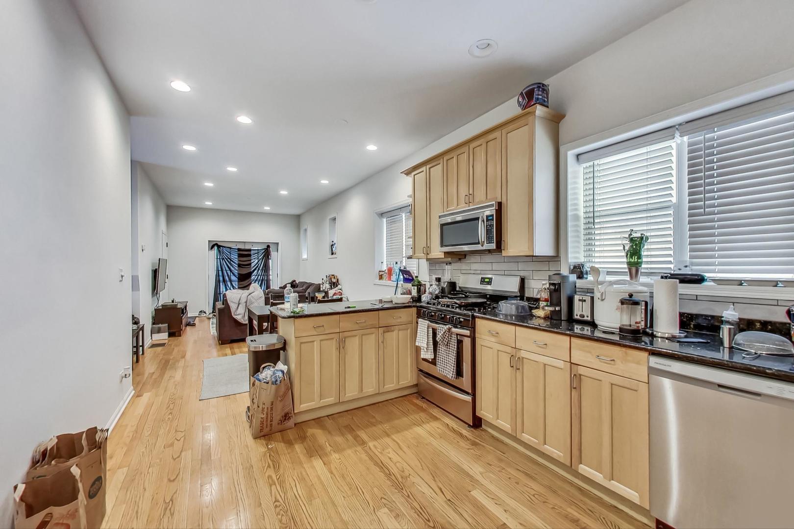 1119 West Addison Street Chicago, IL 60613 - Photo 8 of 36 a kitchen with stainless steel appliances granite countertop sink stove top oven and cabinets