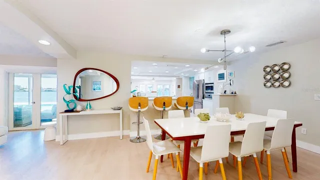 a living room with furniture kitchen view and a wooden floor