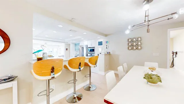 a large white kitchen with lots of counter space a refrigerator and a stove