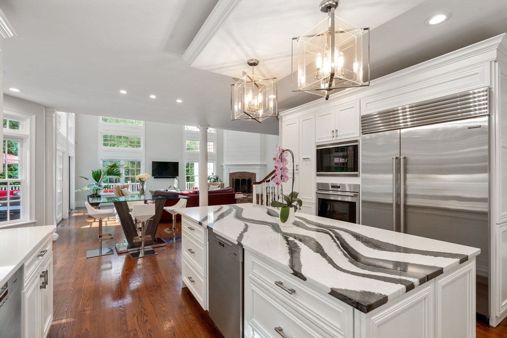 55 Radcliffe Road Weston, MA 02493 - Photo 4 of 38 a kitchen with stainless steel appliances granite countertop a refrigerator a oven a kitchen island a couches and chairs with wooden floor