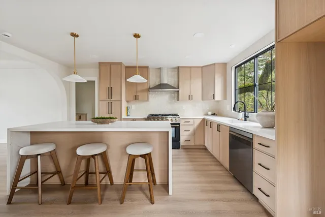 a kitchen with kitchen island granite countertop a sink a counter top space and stainless steel appliances