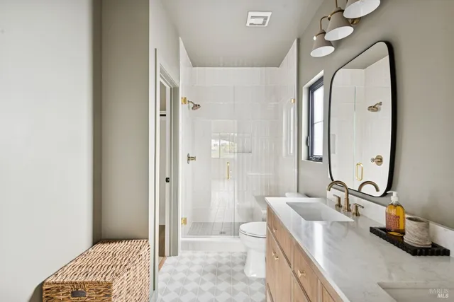 a bathroom with a sink a toilet and shower