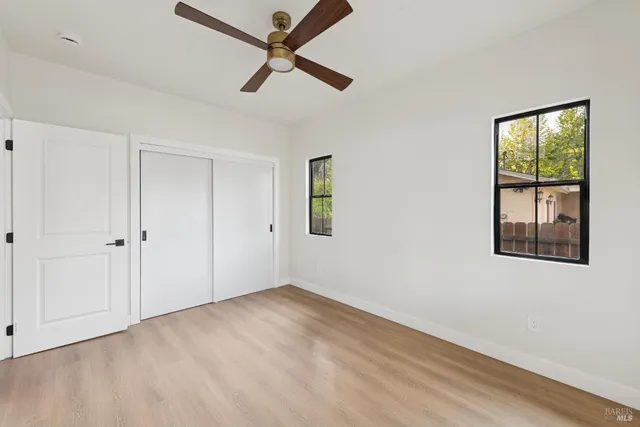 a view of a big room with wooden floor and windows