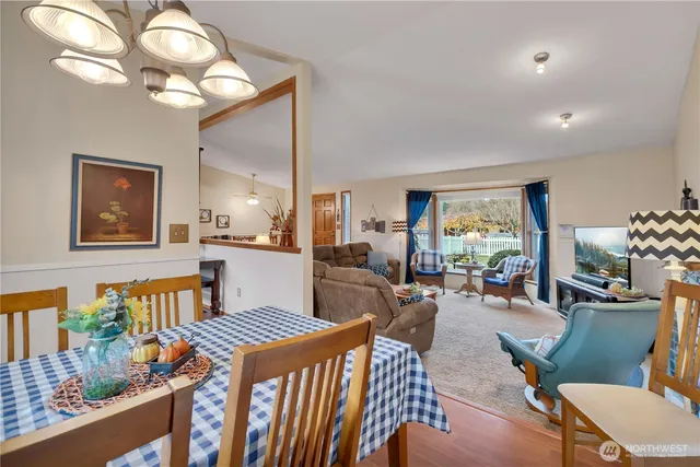 a living room with furniture a chandelier and a dining table