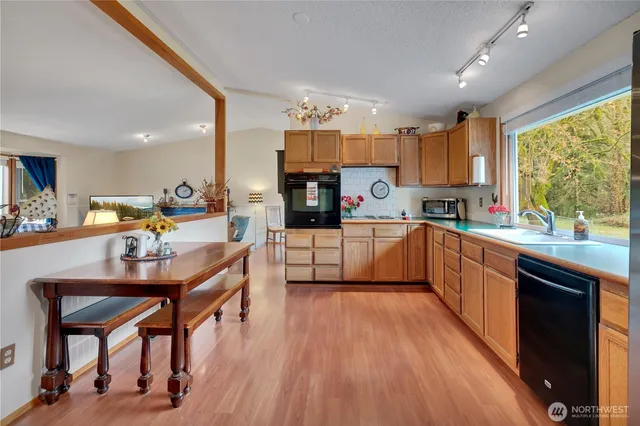 a kitchen with stainless steel appliances kitchen island granite countertop wooden floors and view living room