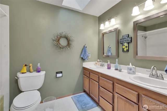 a bathroom with a toilet sink vanity granite and mirror