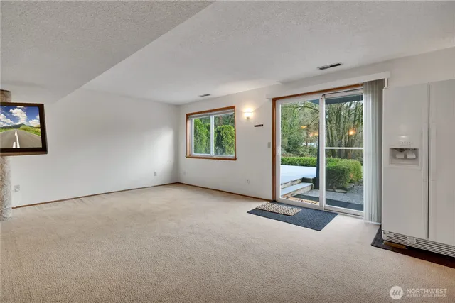 a view of an empty room with a fireplace and a window