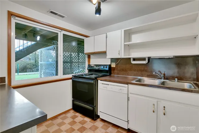 a kitchen with granite countertop a sink stainless steel appliances and cabinets