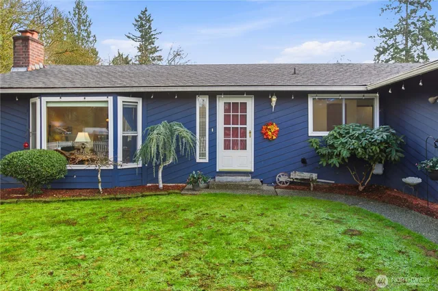 front view of a brick house with a yard and plants