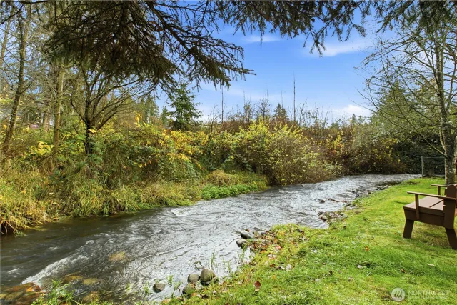 a backyard of a house with table and chairs under an umbrella