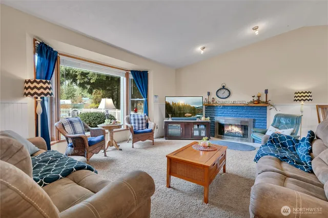 a living room with furniture a fireplace and a floor to ceiling window