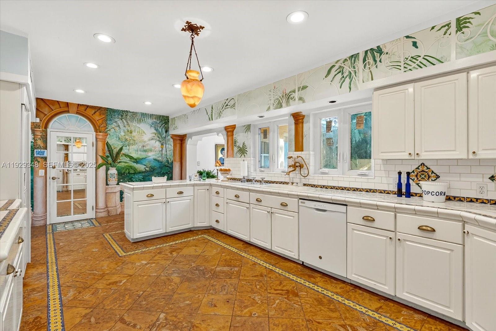 4190 Ingraham Highway Miami, FL 33133 - Photo 14 of 26 a large kitchen with kitchen island granite countertop lots of white cabinets and stainless steel appliances