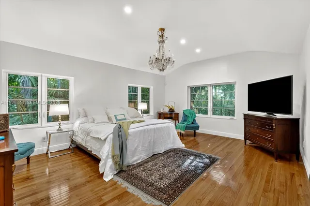 a bedroom with a large bed and a flat screen tv