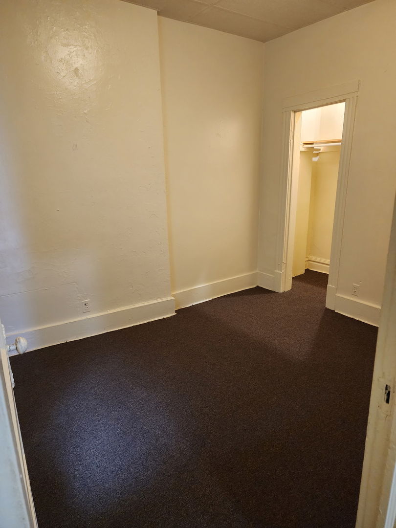 6527 South Kimbark Avenue, Unit 1F Chicago, IL 60637 - Photo 9 of 18 an empty room with a door