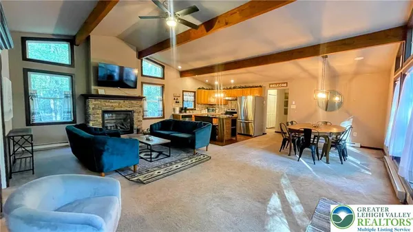 a living room with furniture a fireplace and a large window