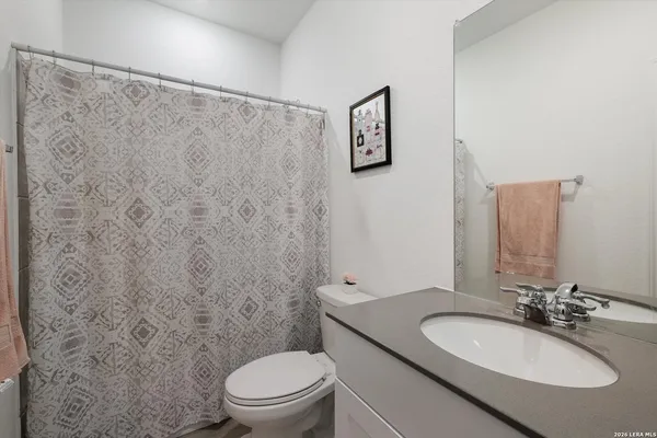 a bathroom with a granite countertop sink a toilet and a mirror
