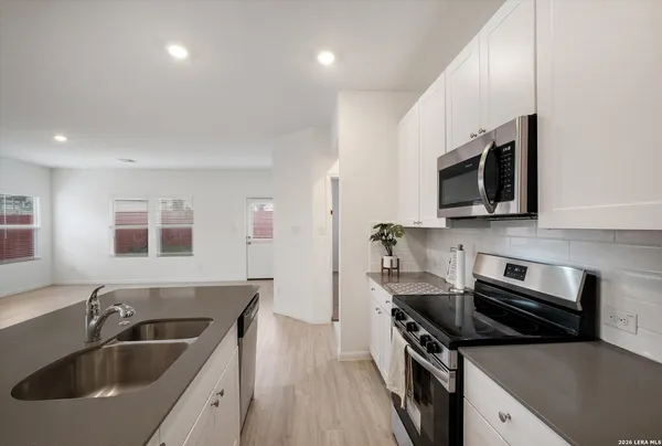 a kitchen with stainless steel appliances a sink a stove and microwave