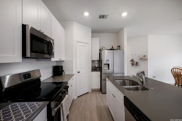 a kitchen that has a sink and a stove top oven