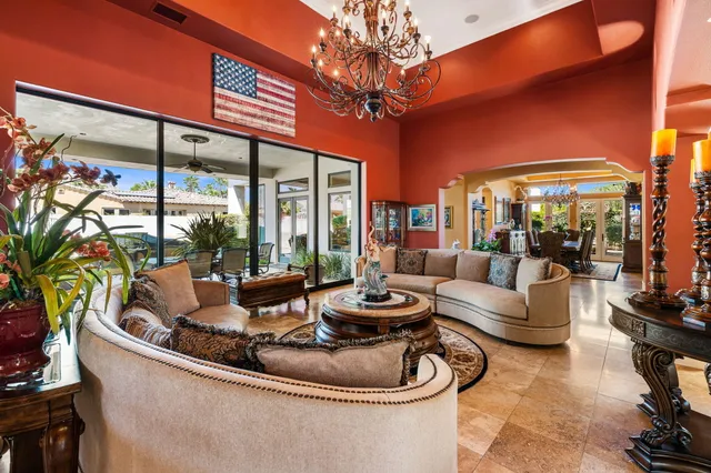 a living room with patio furniture and a chandelier