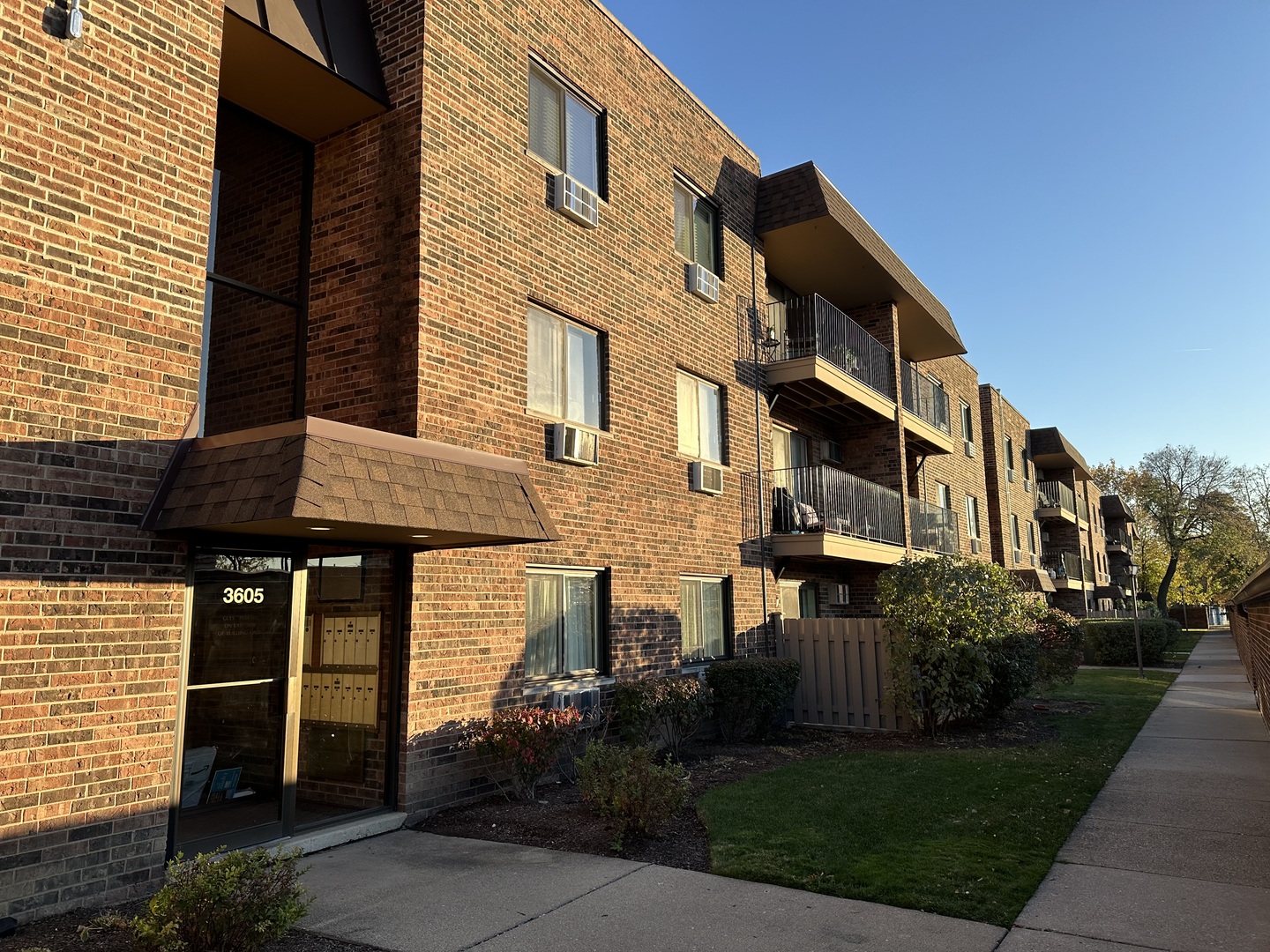 3609 Central Road, Unit 302 Glenview, IL 60025 - Photo 3 of 15 a view of a brick house with many windows plants and palm trees