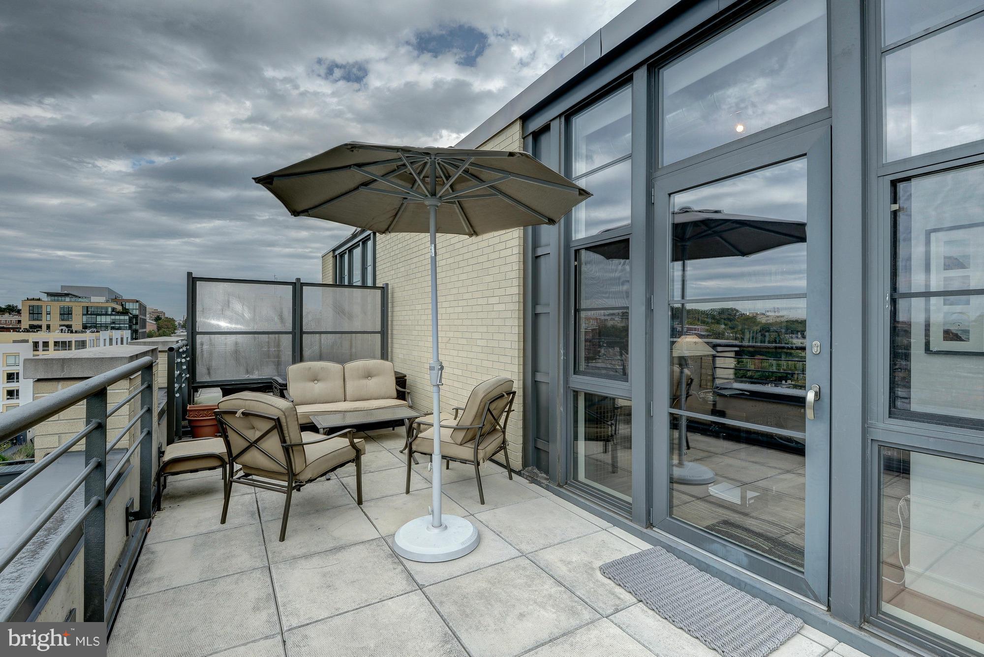 2125 14th Street Northwest, Unit 913 Washington, DC 20009 - Photo 12 of 14 a patio with a table and chairs under an umbrella