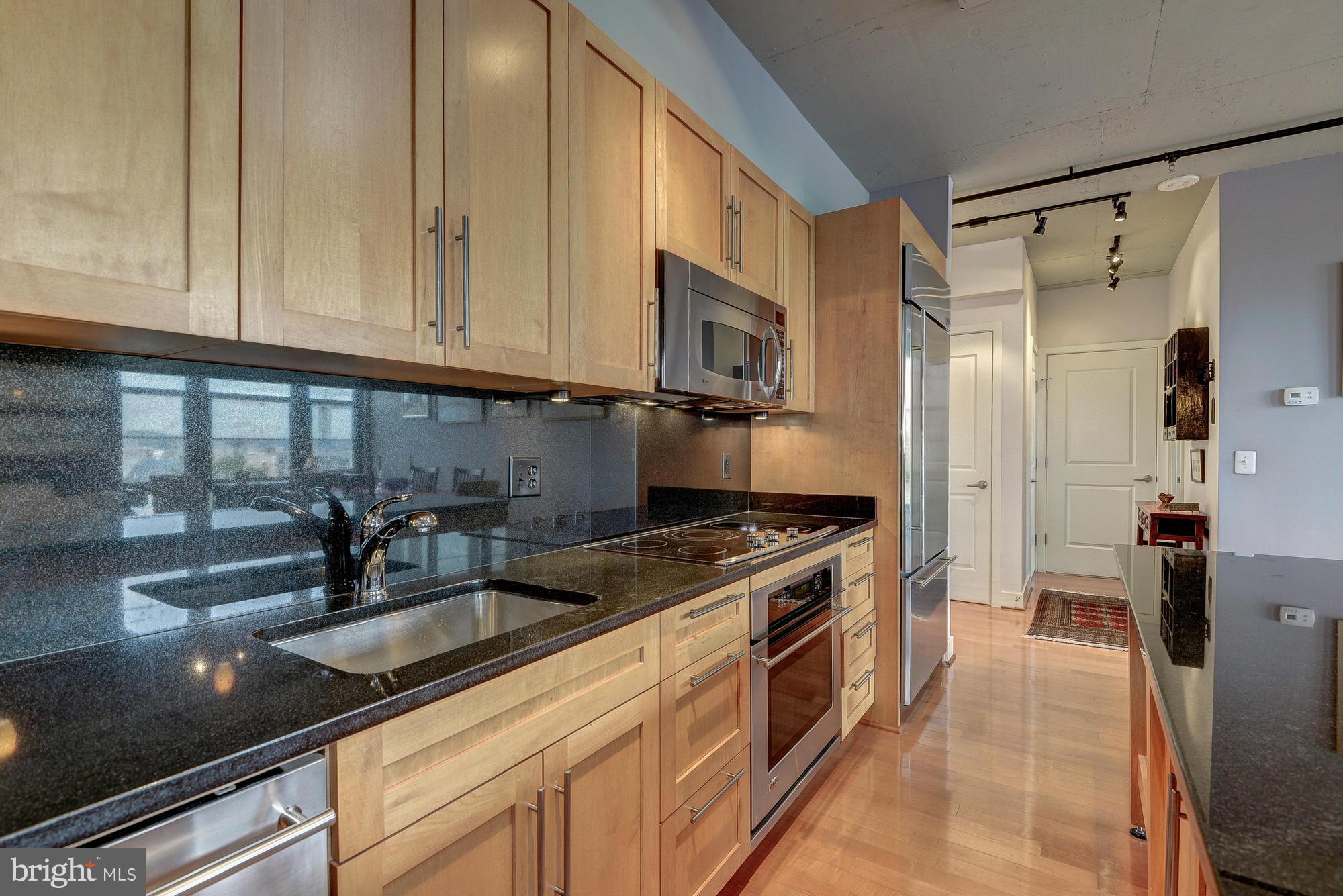 2125 14th Street Northwest, Unit 913 Washington, DC 20009 - Photo 3 of 14 a kitchen with granite countertop a sink a stove and refrigerator