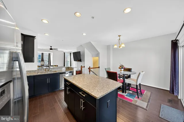 a open kitchen with stainless steel appliances granite countertop a sink dishwasher a stove and a refrigerator with wooden floor