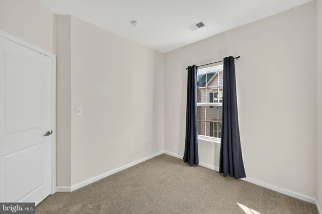 a view of an empty room with wooden floor and entryway