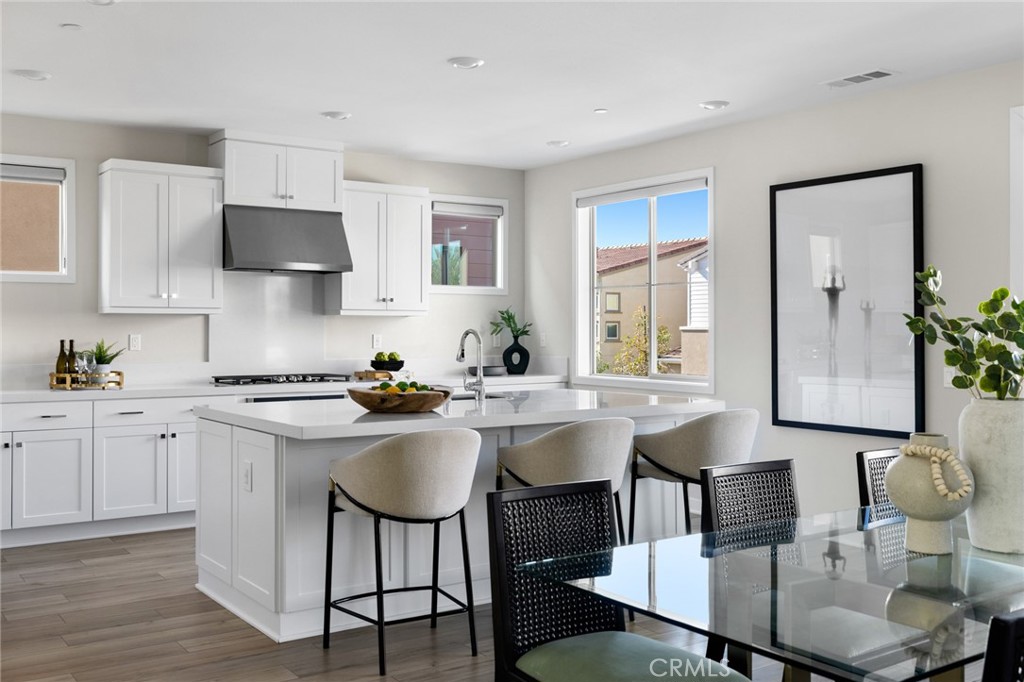 526 Serrano Summit Drive Lake Forest, CA 92630 - Photo 5 of 59 a kitchen with a dining table chairs and white cabinets