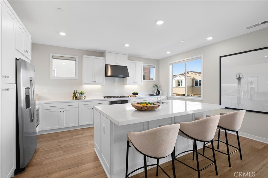 526 Serrano Summit Drive Lake Forest, CA 92630 - Photo 6 of 59 a kitchen with refrigerator cabinets dining table and chairs