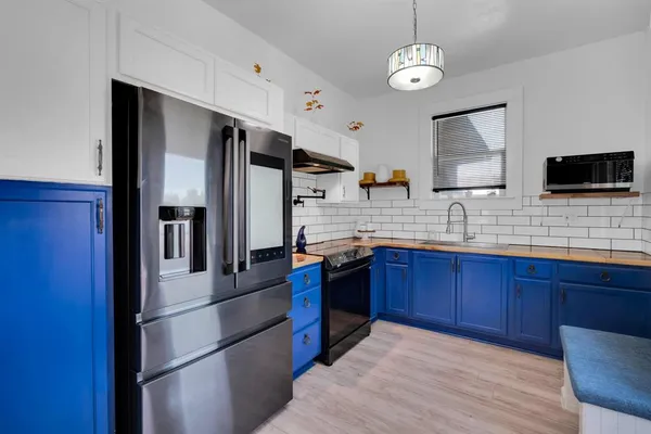 a kitchen with stainless steel appliances granite countertop a refrigerator and a stove top oven