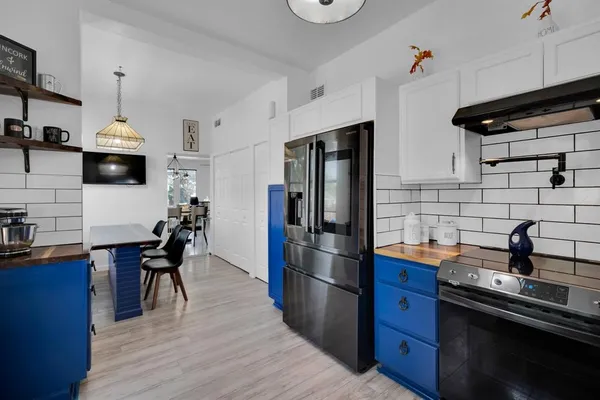 a kitchen with stainless steel appliances a sink cabinets and wooden floor