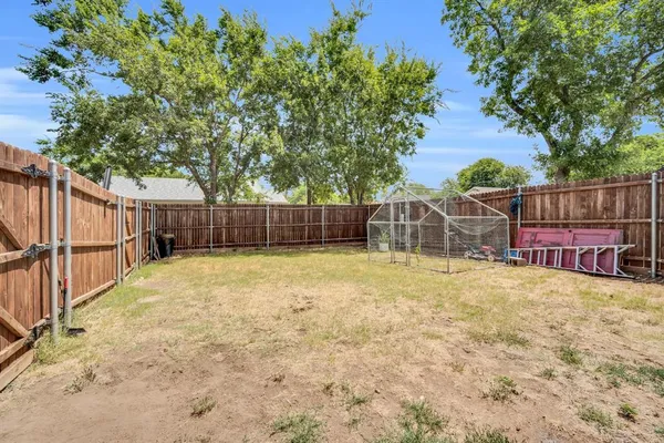 a view of a backyard with wooden fence