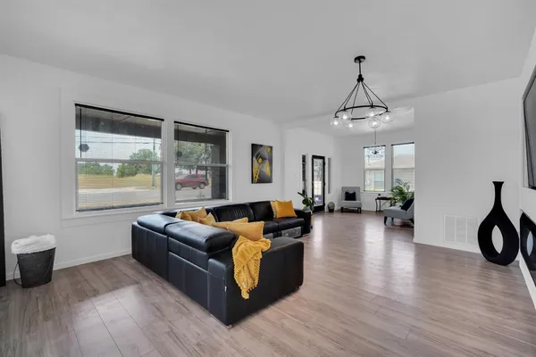 a living room with furniture and a wooden floor