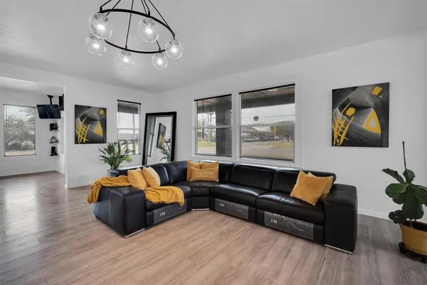 a living room with furniture a wooden floor and chandelier