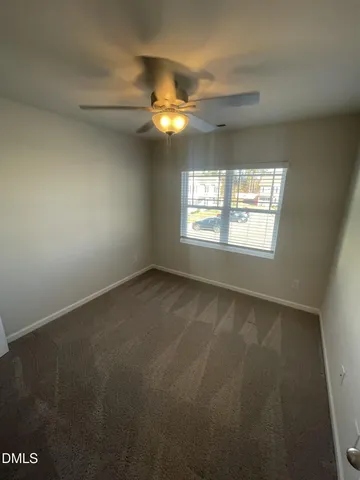 an empty room with closet and windows