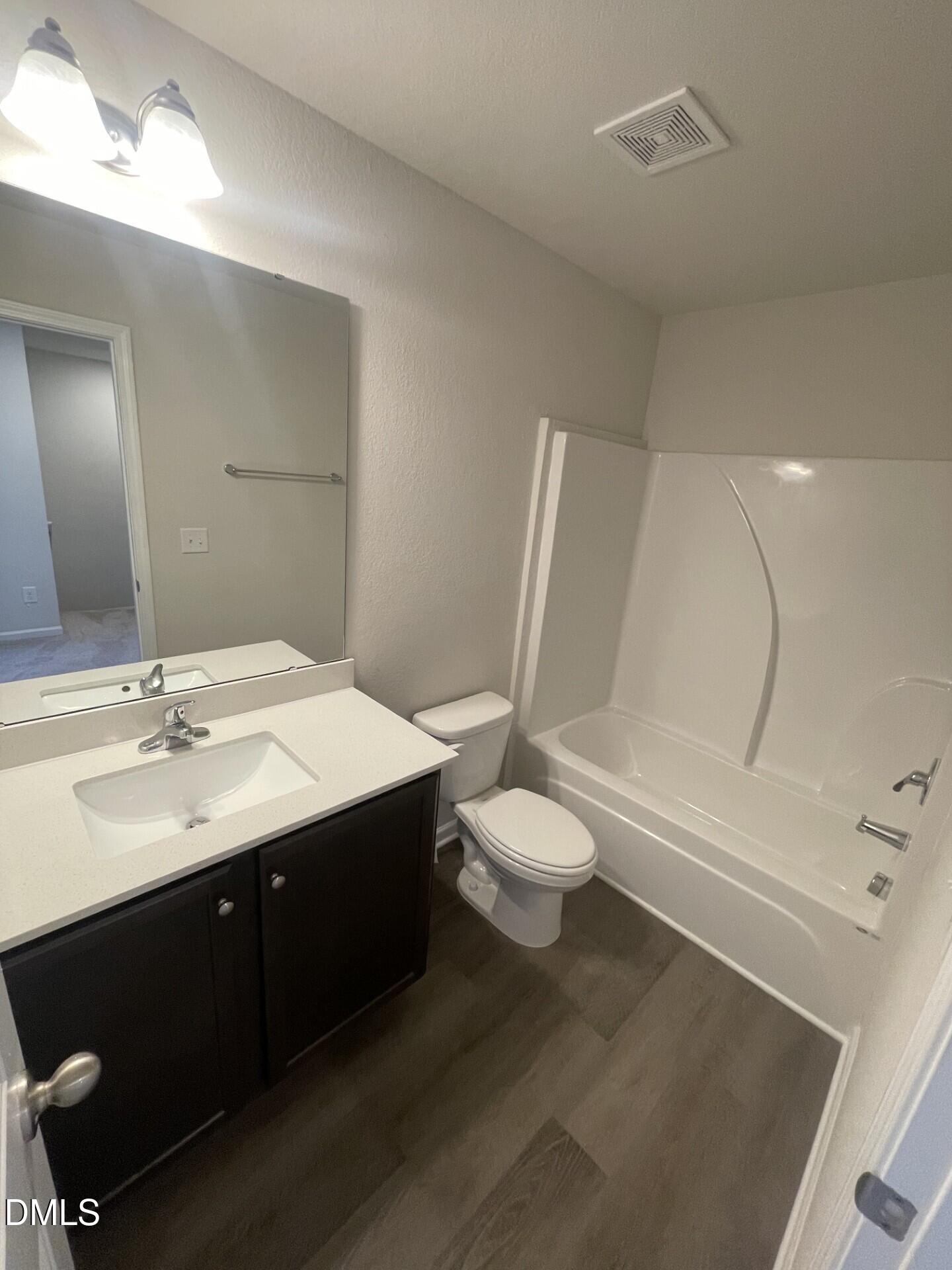 1097 Peony Lane Youngsville, NC 27596 - Photo 15 of 15 a bathroom with a sink a toilet and a mirror