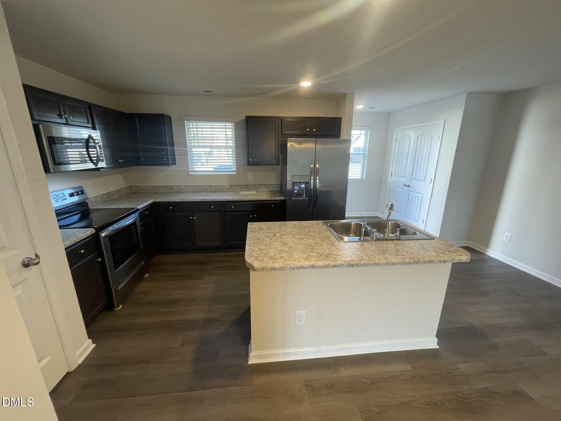 1097 Peony Lane Youngsville, NC 27596 - Photo 5 of 15 a kitchen with stainless steel appliances granite countertop a sink a stove a refrigerator a washer dryer and a cabinets