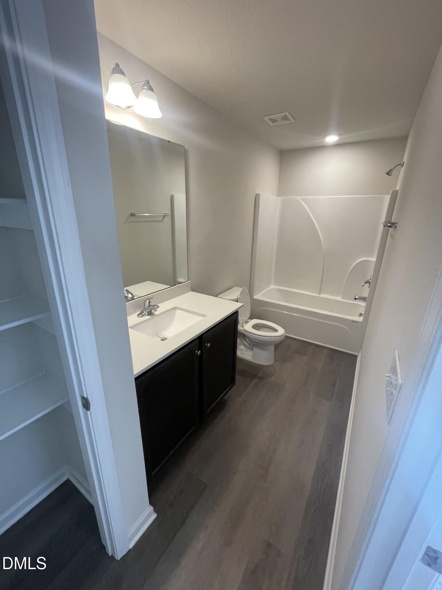 1097 Peony Lane Youngsville, NC 27596 - Photo 8 of 15 a bathroom with a double vanity sink a toilet and a mirror
