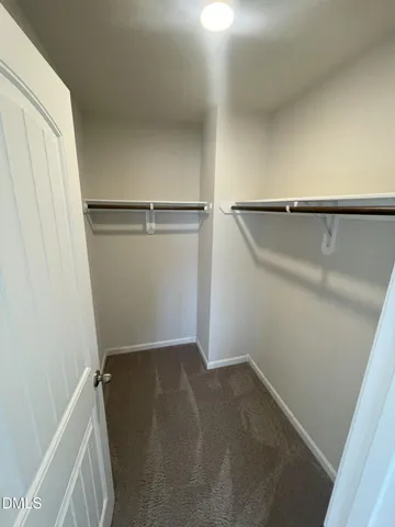 an empty room with wooden floor and sink