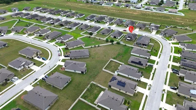 an aerial view of a city with lots of residential buildings ocean and mountain view in back