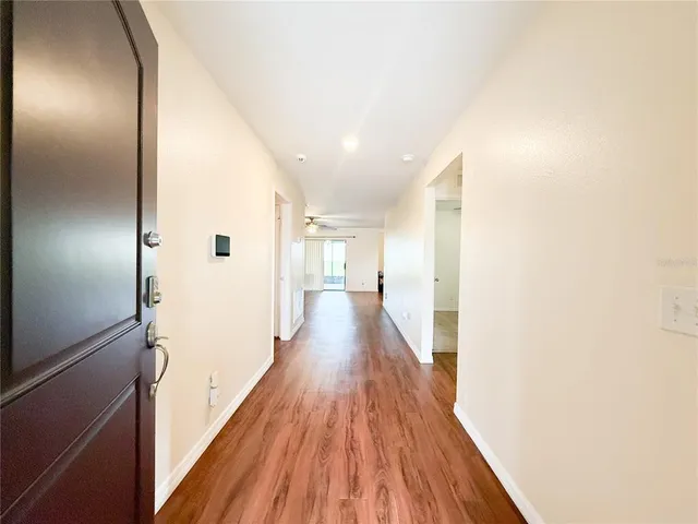 a view of a hallway with wooden floor