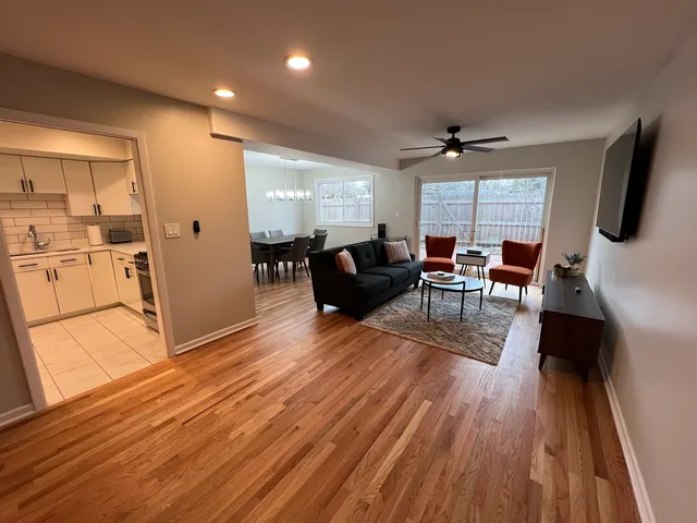 a living room with furniture a flat screen tv and wooden floor