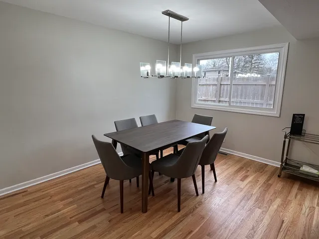 a view of a dining room with furniture wooden floor and chandelier
