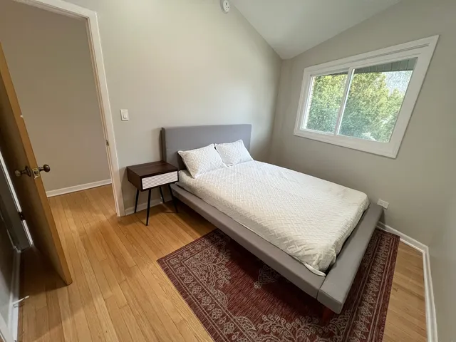 a bed sitting in a bedroom next to a window