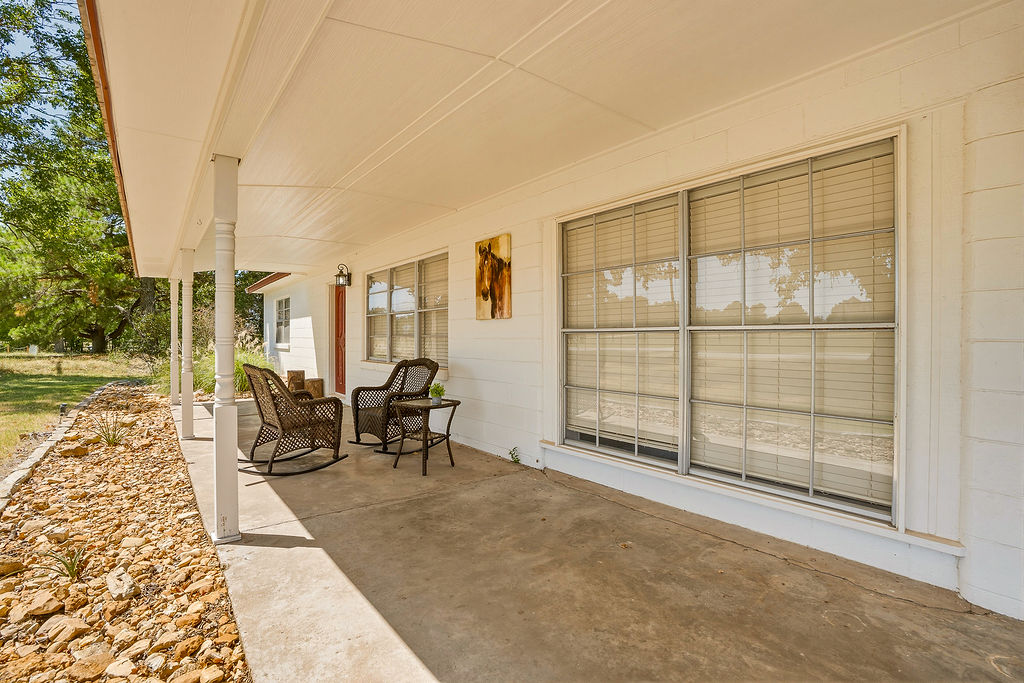 1009 Southeast County Road Ada, OK 74820 - Photo 85 of 92 Covered front porch with concrete flooring, support columns, and exterior lighting fixture